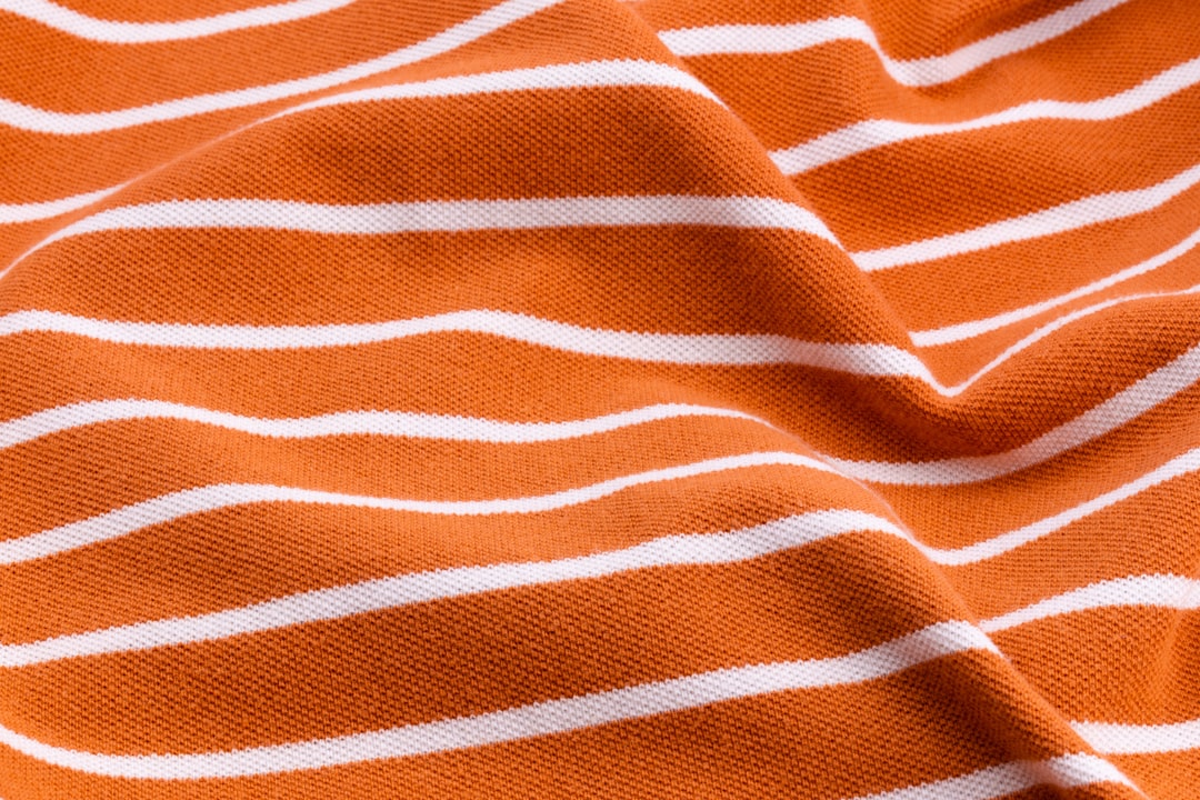 Beautiful summer background made of striped twisted and wrinkled fabric of delicate colors orange.